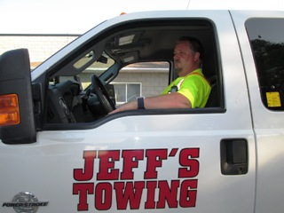 A Jeff's tow truck with driver.